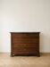 Antique wooden chest of drawers with a marble top.