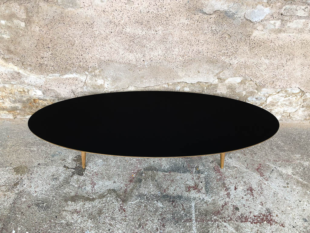 Oval coffee table with a black tray and oak-turned feet