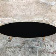 Oval coffee table with a black tray and oak-turned feet