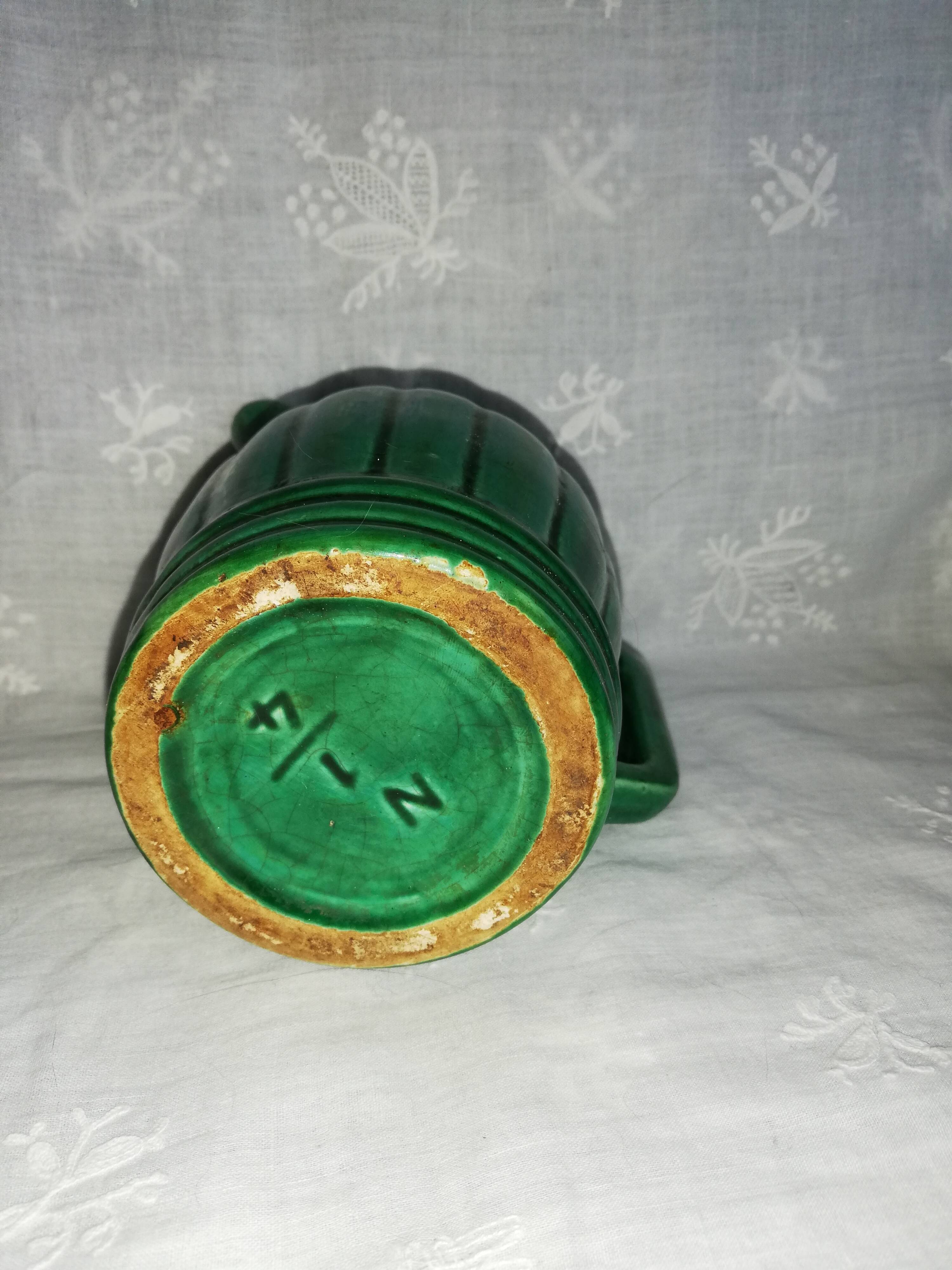 Old green pitcher in dabbling