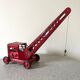 Grue de chantier rouge en tôle datant des années 60 avec mécanisme manuel