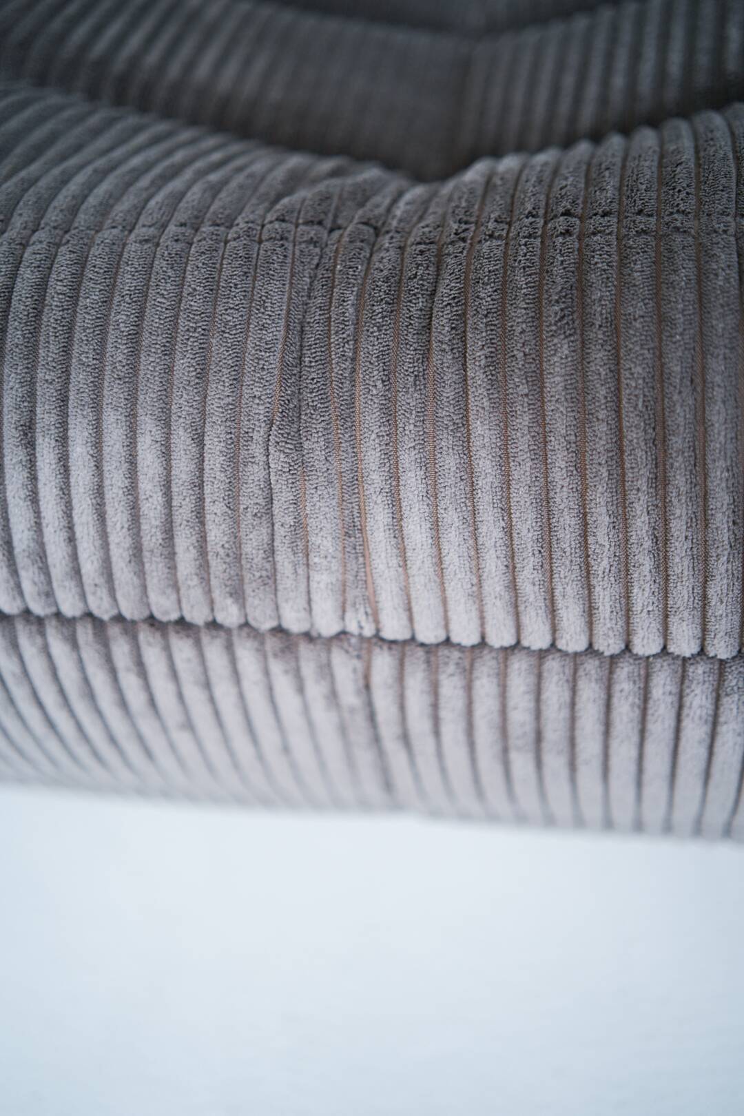Ensemble de chaise et pouf Togo en velours côtelé marron.