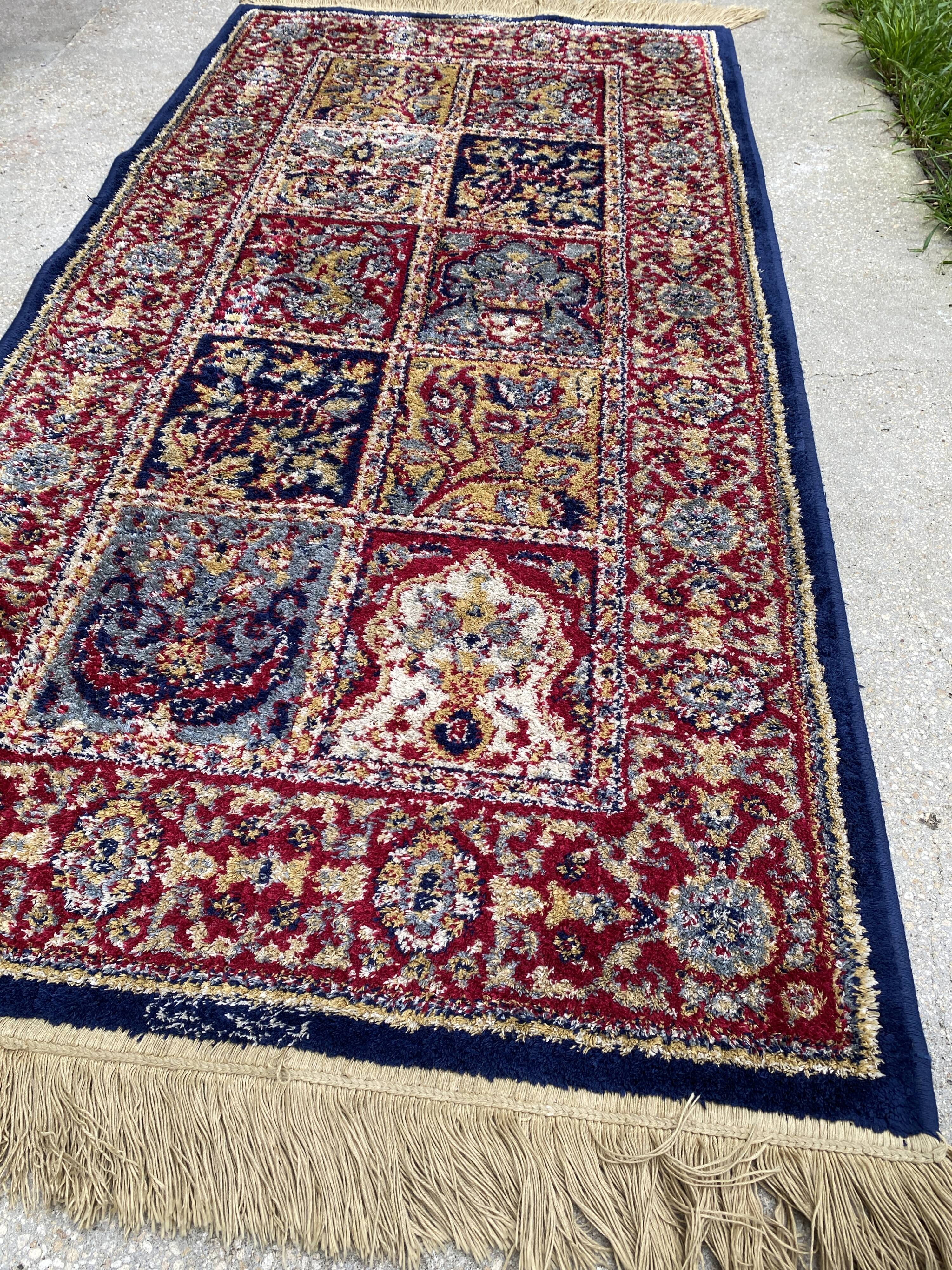 Vintage mechanical Turkish rug with box decoration on a red and navy blue background 139 x 68 cm