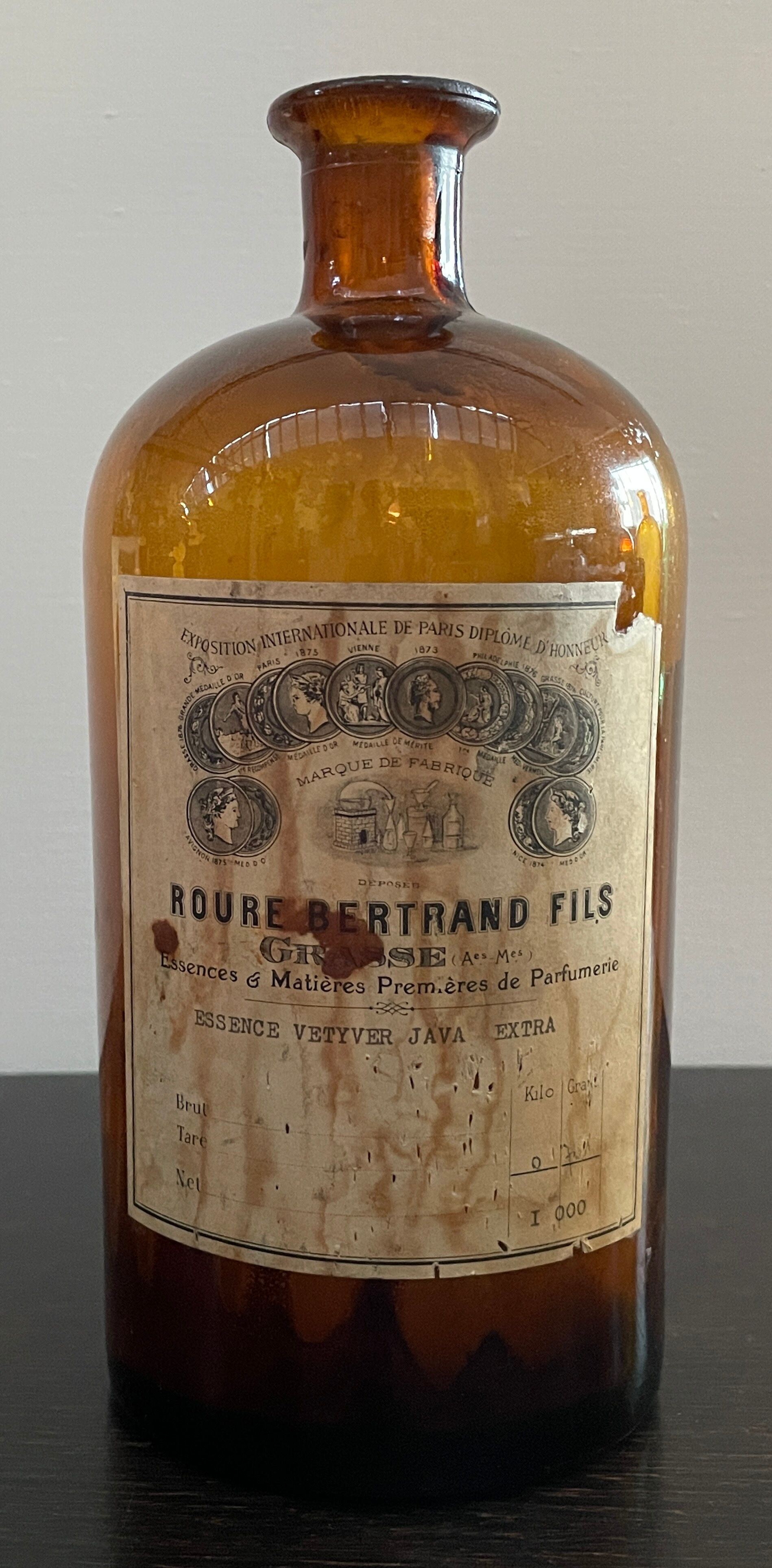 Lot d'anciens flacons de parfumeurs en verre avec étiquettes d'origine