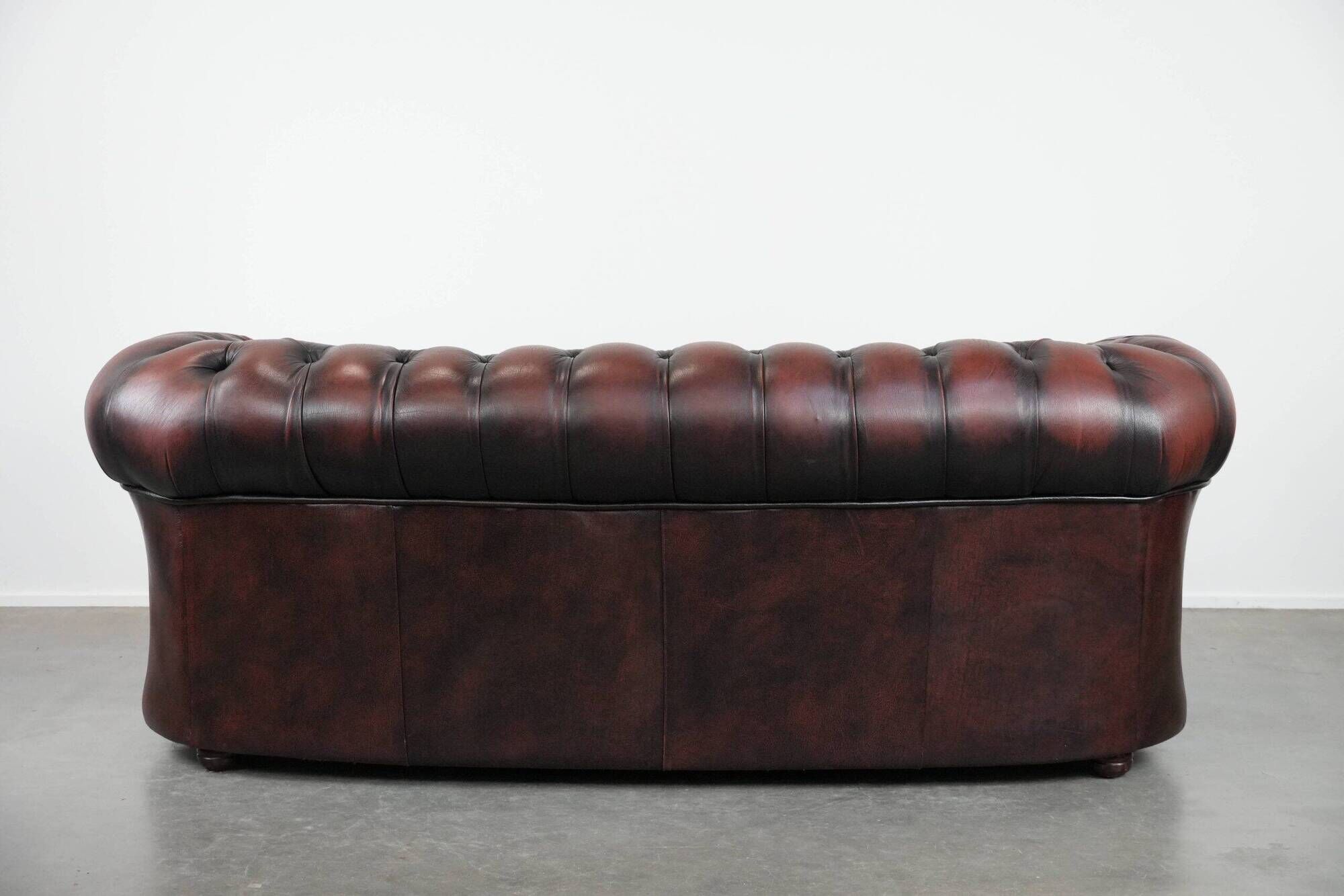 Classic cowhide Chesterfield sofa in English style with red/brown colours