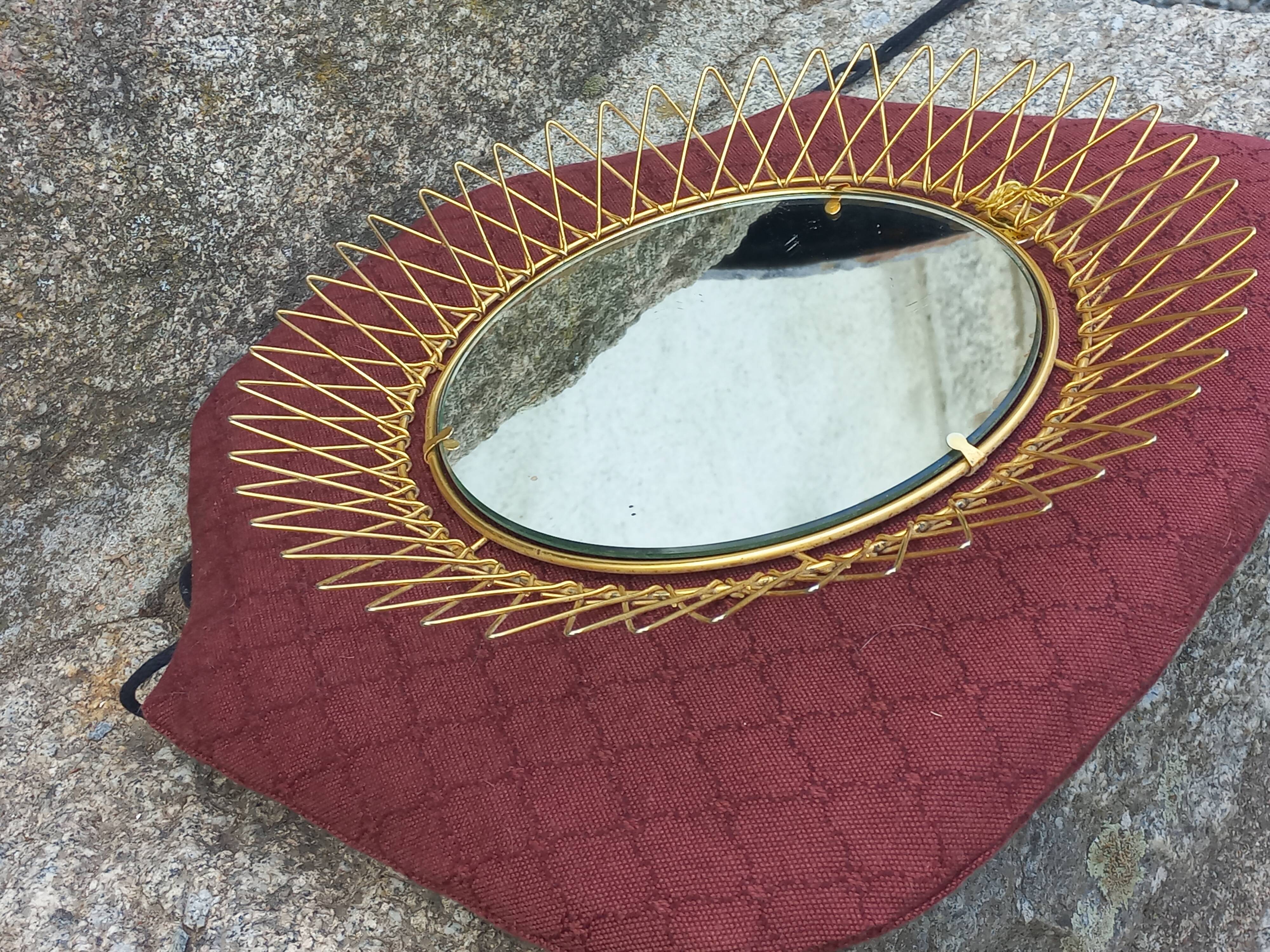 Vintage 1950s sun mirror in gold metal.
