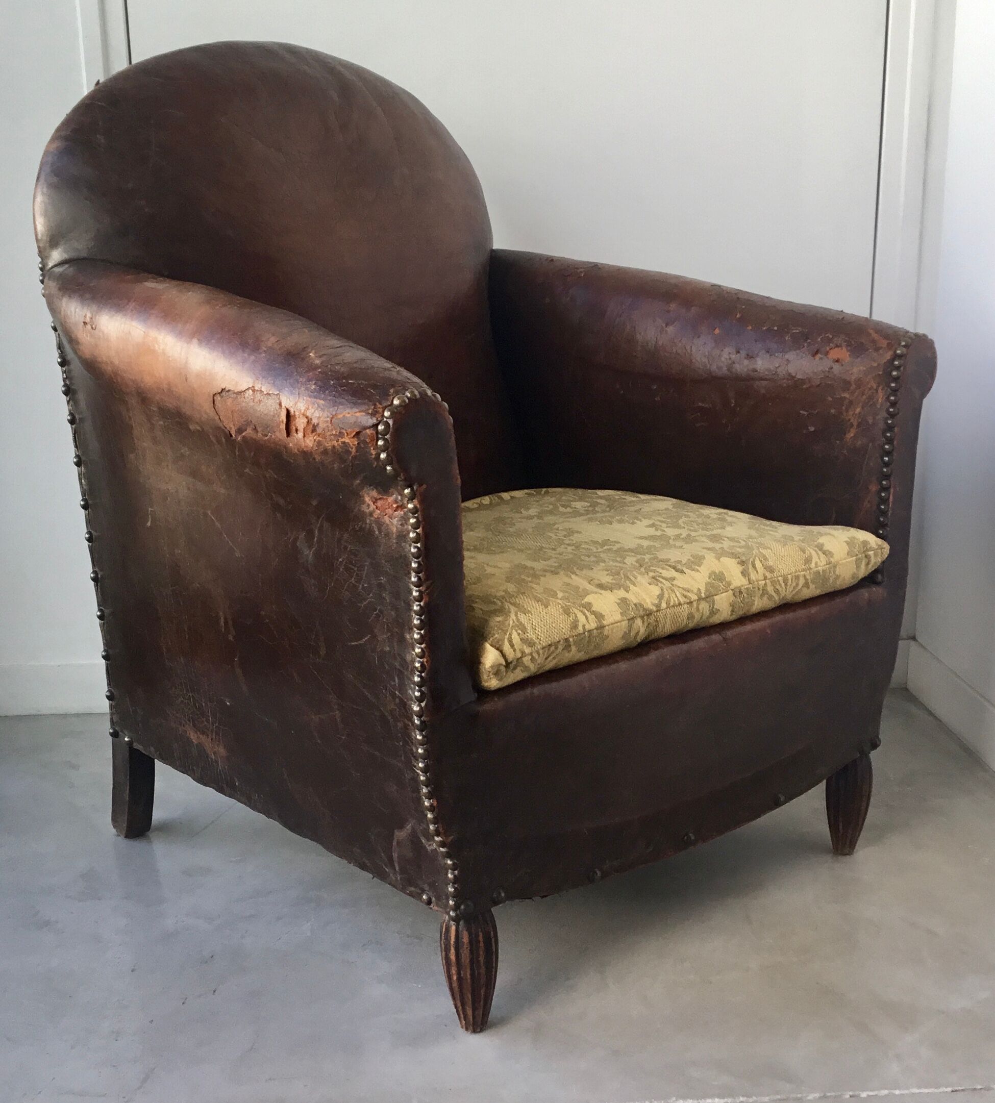 Club armchair in studded leather - early twentieth century