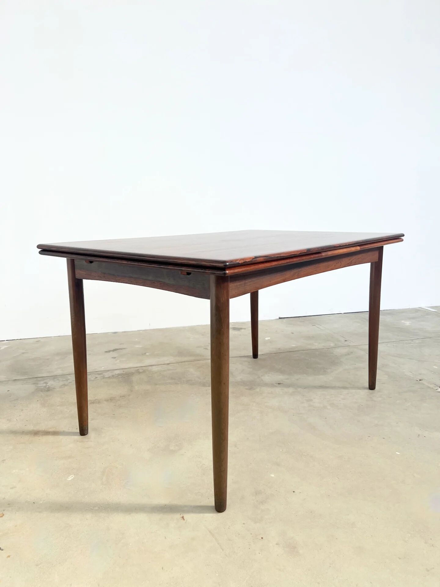 Rosewood dining table with integrated extensions — Denmark, 1960s