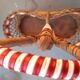Bottle holder in braided wicker, rattan and scoubidou