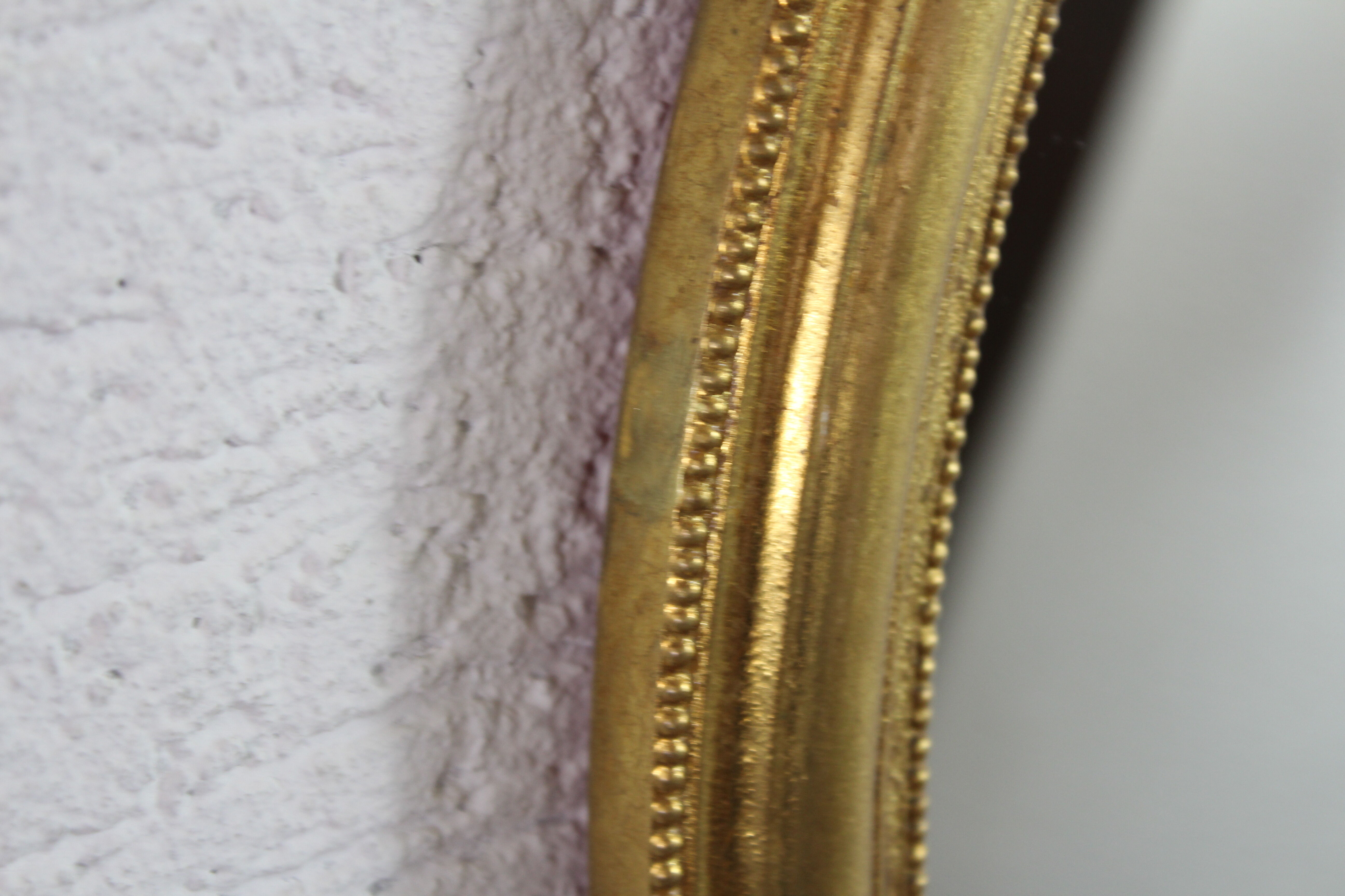 Golden oval mirror with leaf