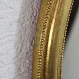 Golden oval mirror with leaf