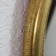 Golden oval mirror with leaf