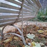 Pair of antique wooden slatted benches with wrought iron legs.