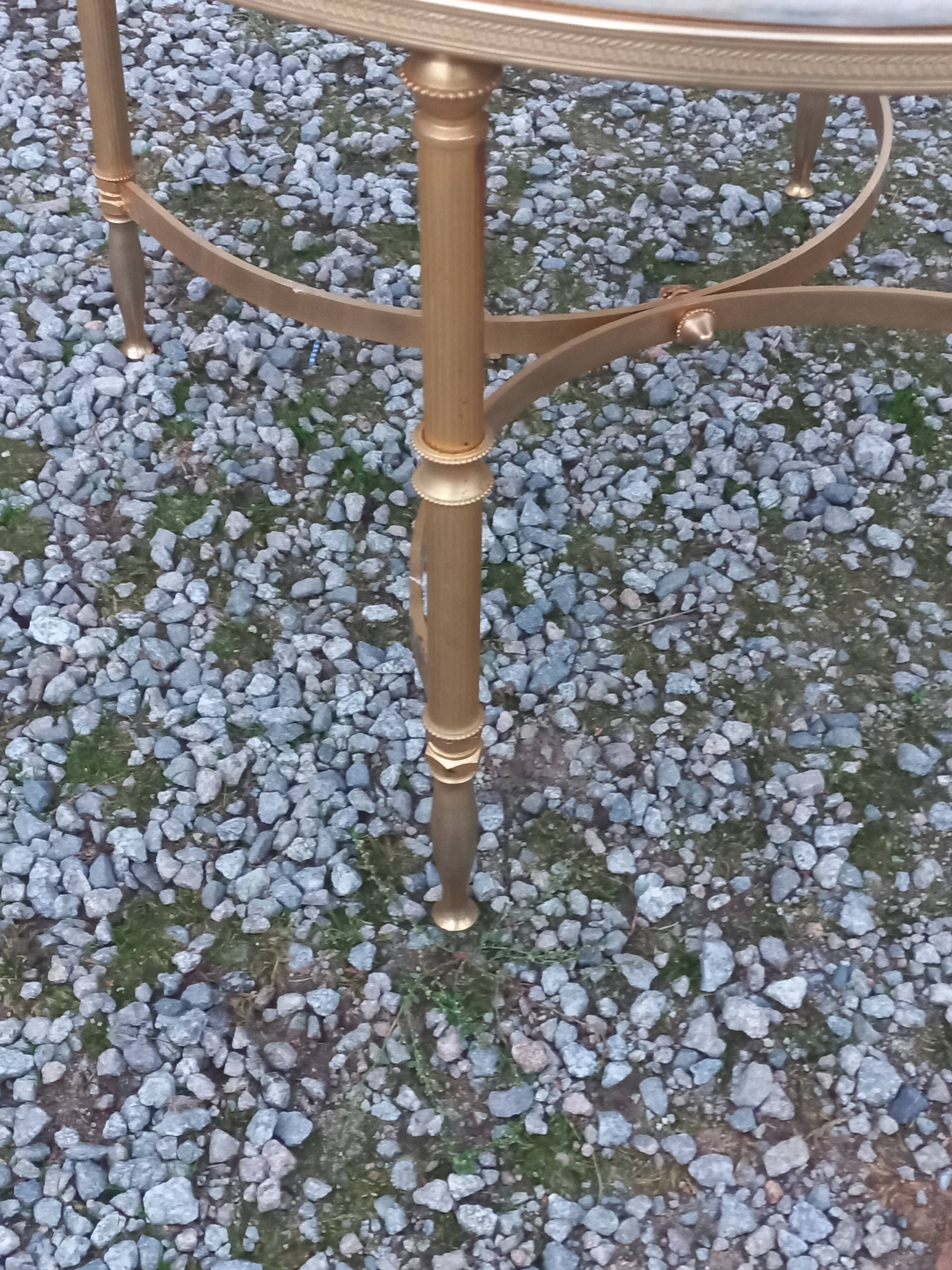 Round neoclassical coffee table with a marble top and golden metal base.