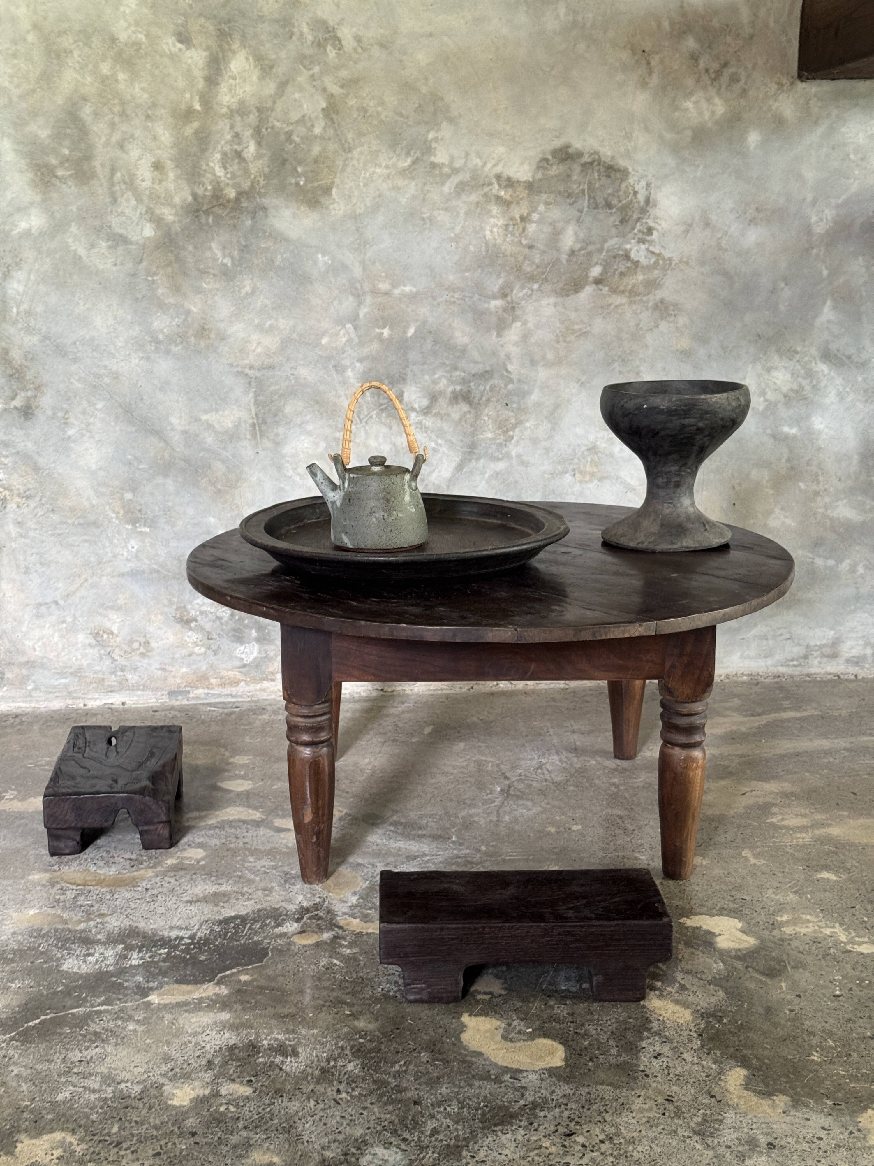 Coffee table, round antique Indonesian teak table with straight legs.