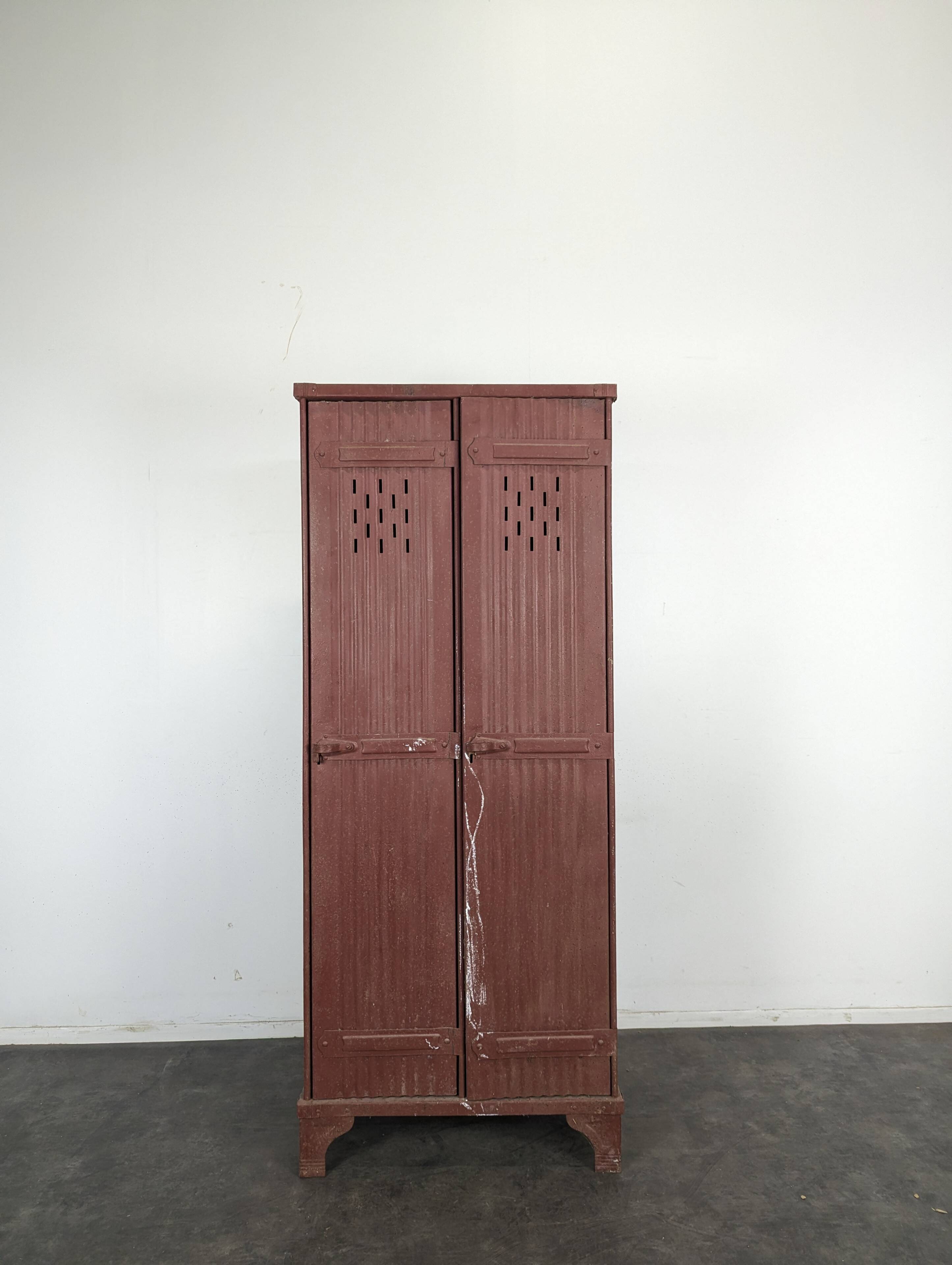 Red painted metal workshop locker with two doors.