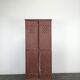 Red painted metal workshop locker with two doors.