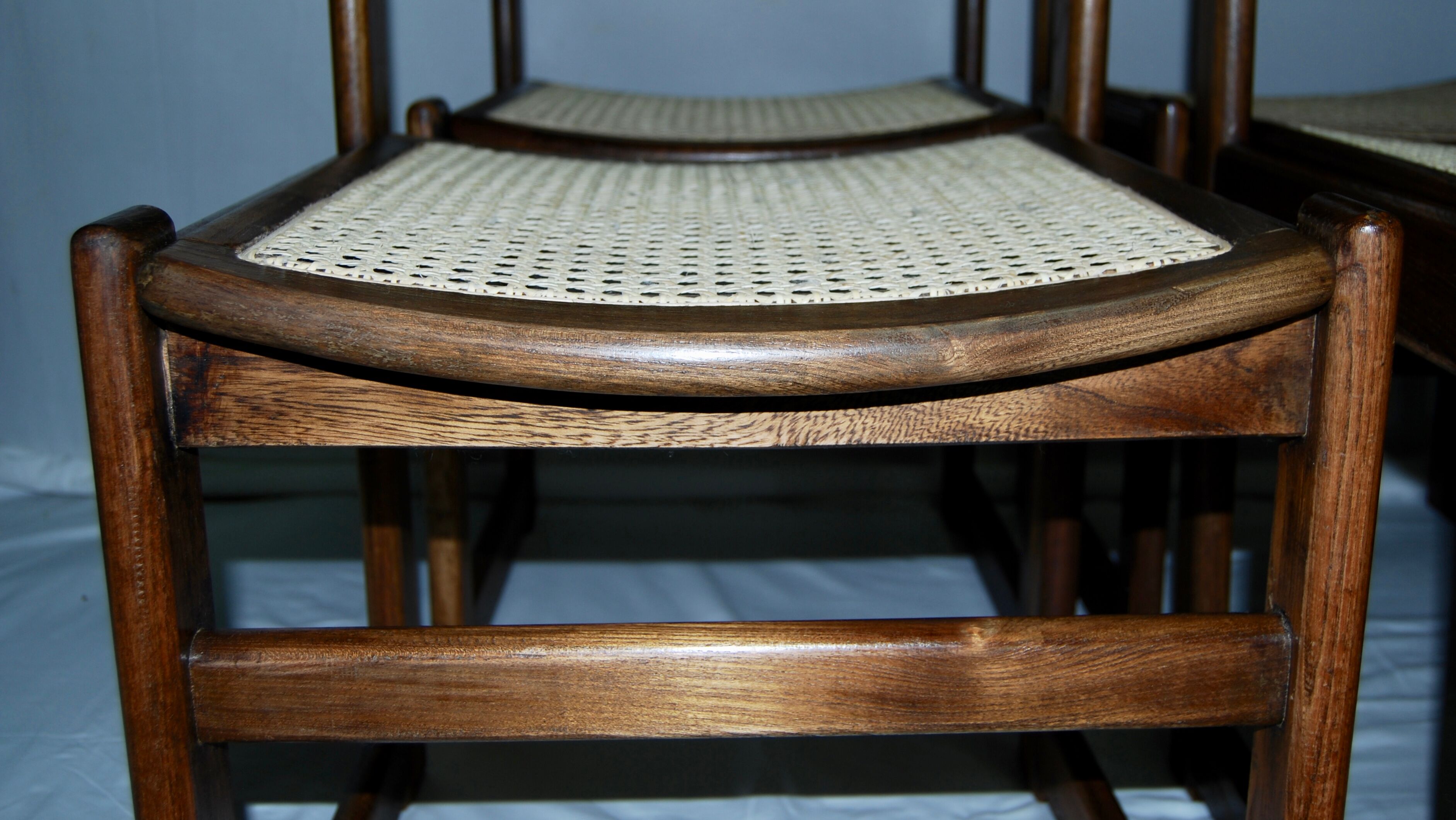 Set of 12 "sledge" dining chairs in walnut and cane.