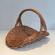 Woven Rattan Log Holder in a Semi-Round Shape with a Central Arched Handle.