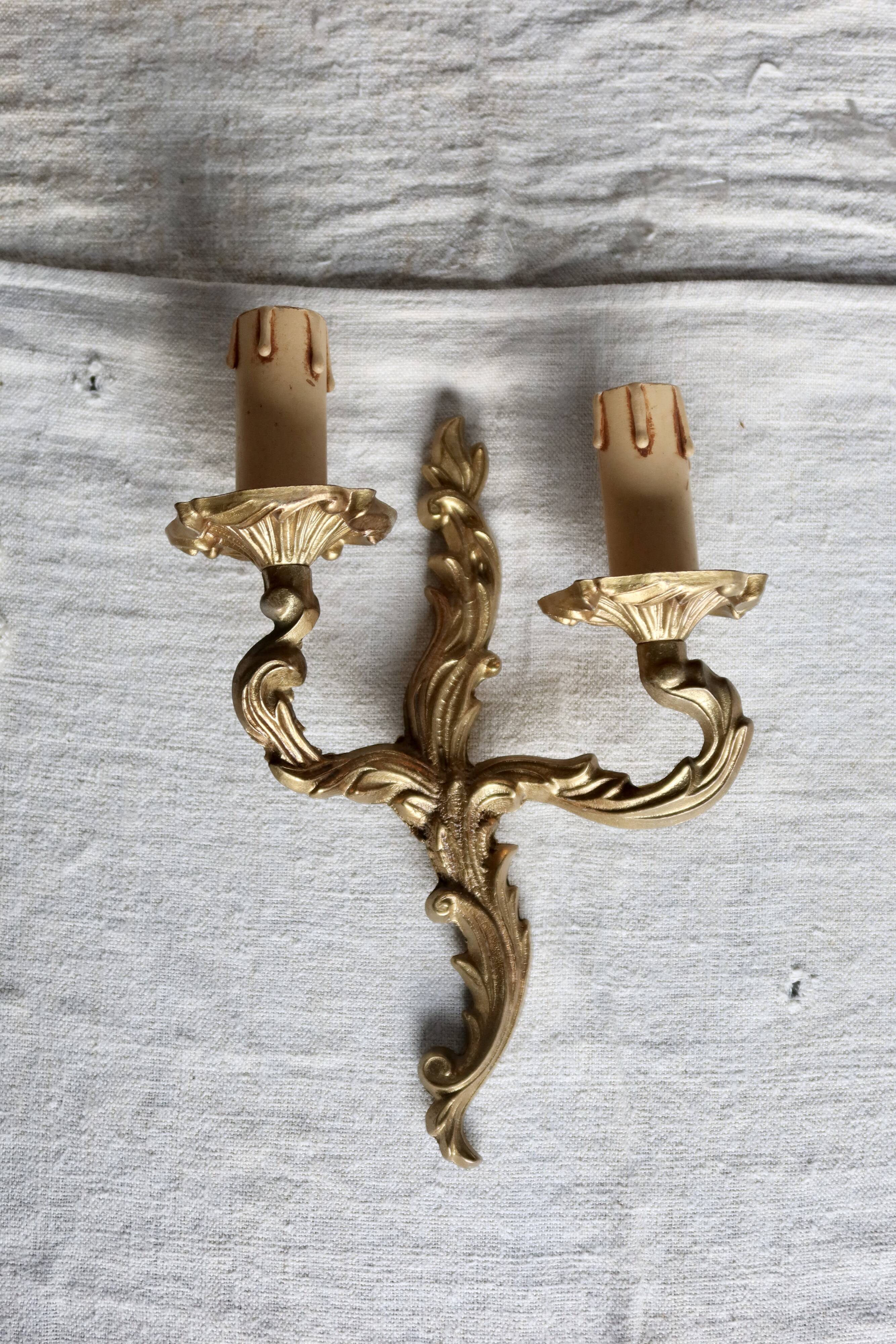 Vintage wall sconce in gold metal with two arms in classic style.