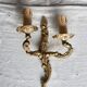 Vintage wall sconce in gold metal with two arms in classic style.