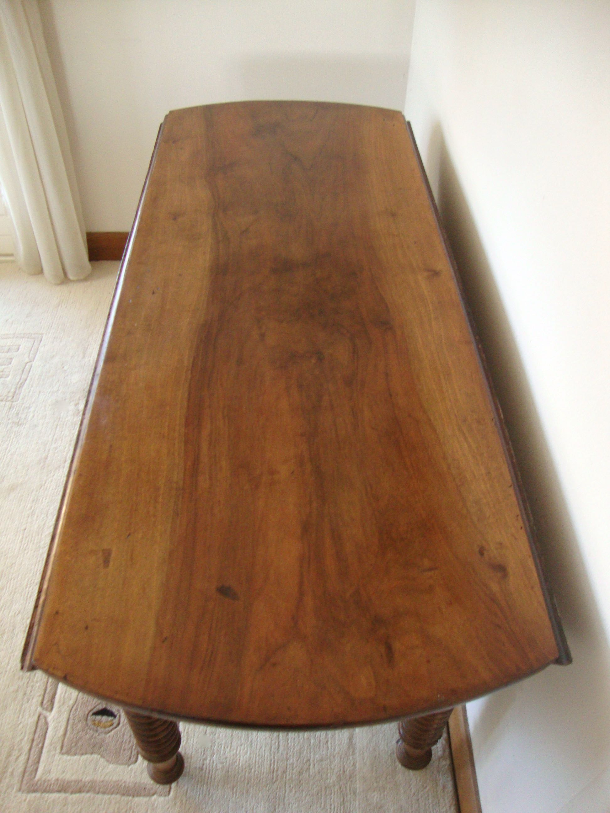 Mid-19th-century walnut round table with shutters, flaps