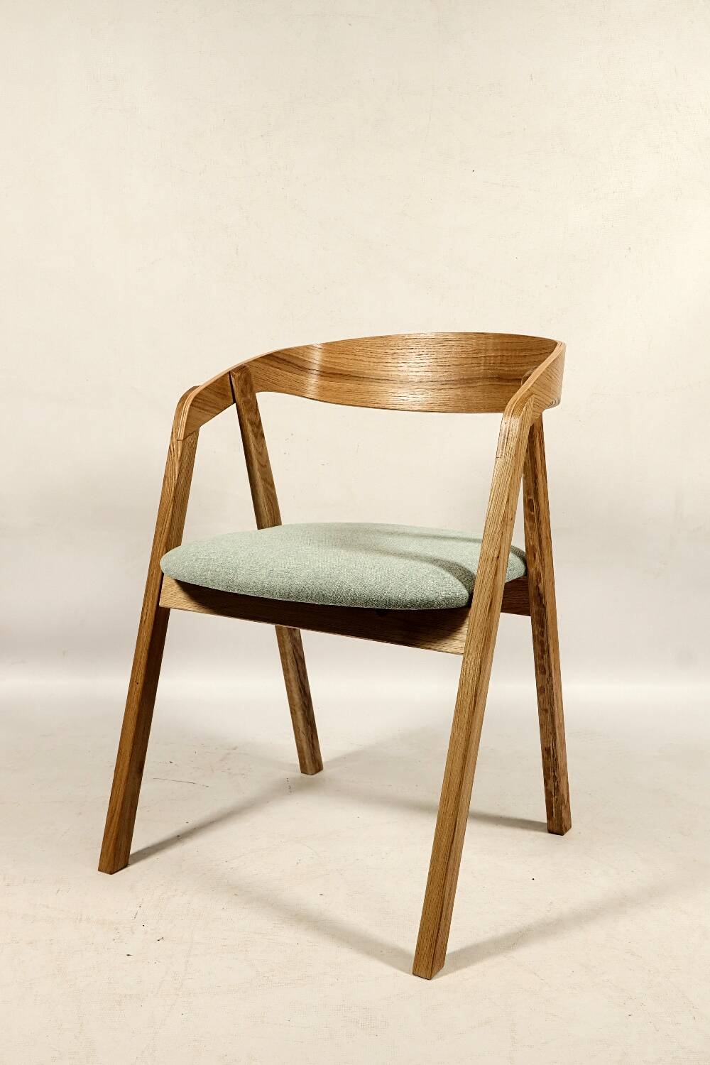 Vintage dining chair in light oak with natural linen pastel green fabric.