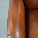 Cognac-colored sheepskin armchair with rounded shapes