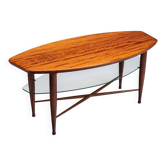 Table basse asymétrique avec rangement en verre et détails de pieds en croix.