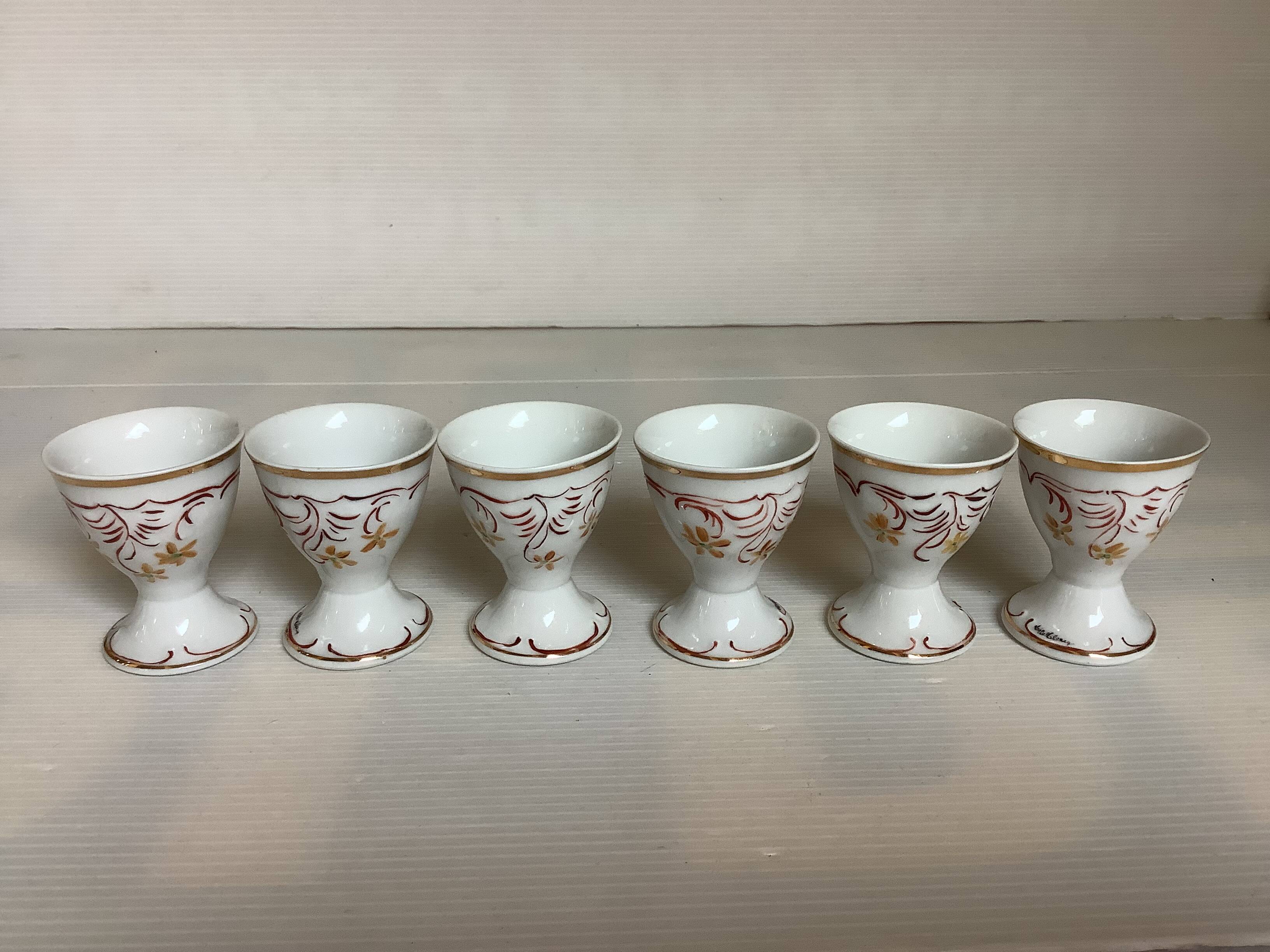 Six hand-decorated and signed egg cups
