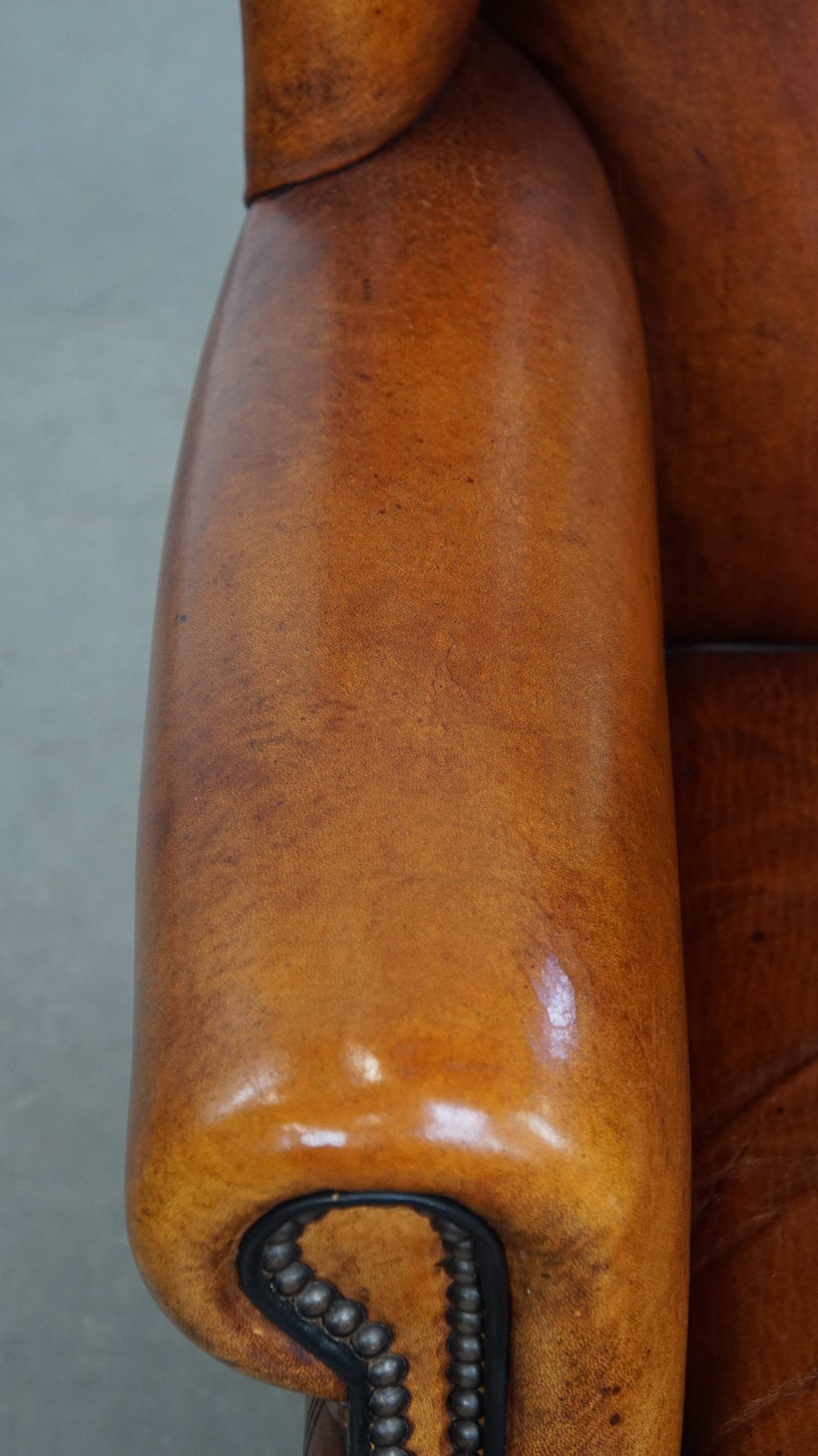 Sheepskin wingback armchair with stitching and black piping