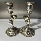 Two silver-plated metal candlesticks decorated with cherubs, 20th century
