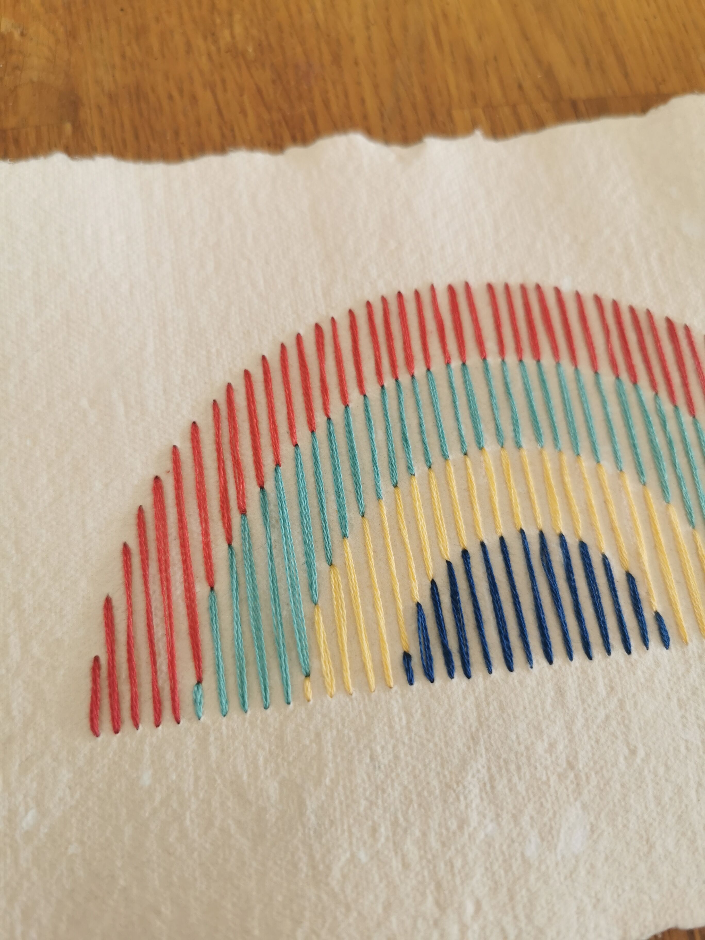 Rainbow embroidery on recycled paper
