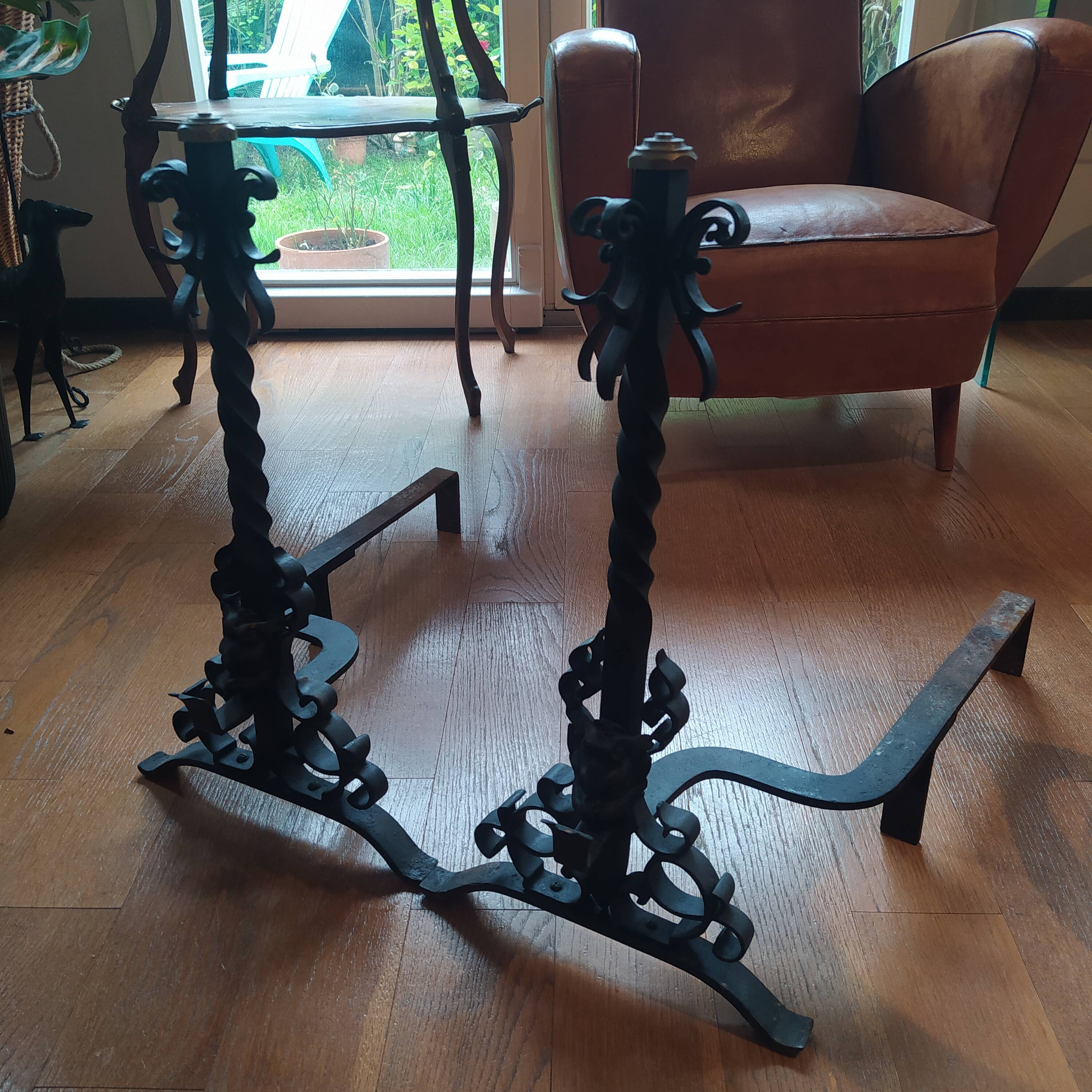 pair of large 20th century metal andirons with mascaron decoration