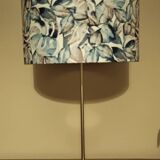 Table lamp with chrome stem, tropical plant shade.