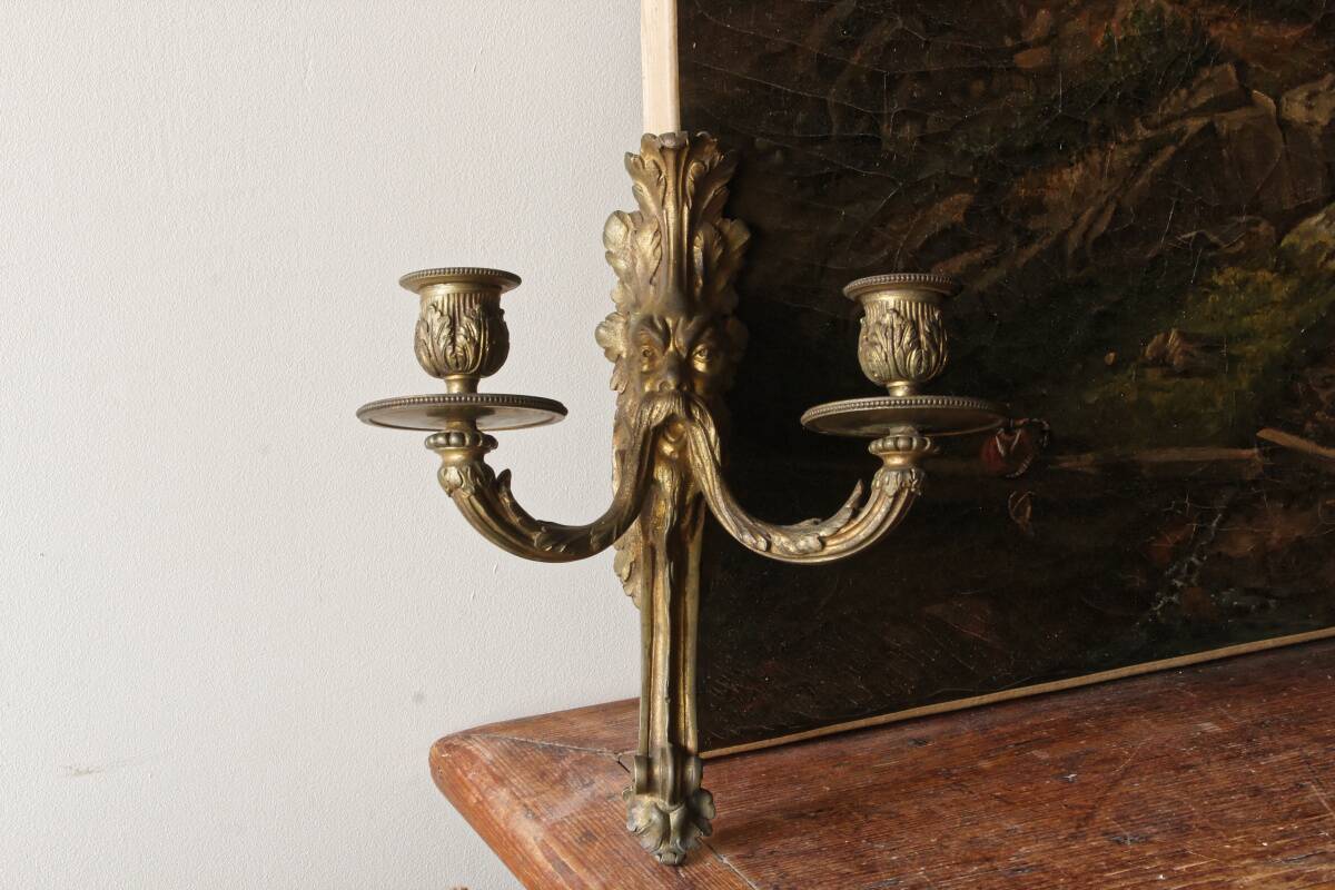 Monobloc gilded bronze wall light, grotesque satyr, two lights.