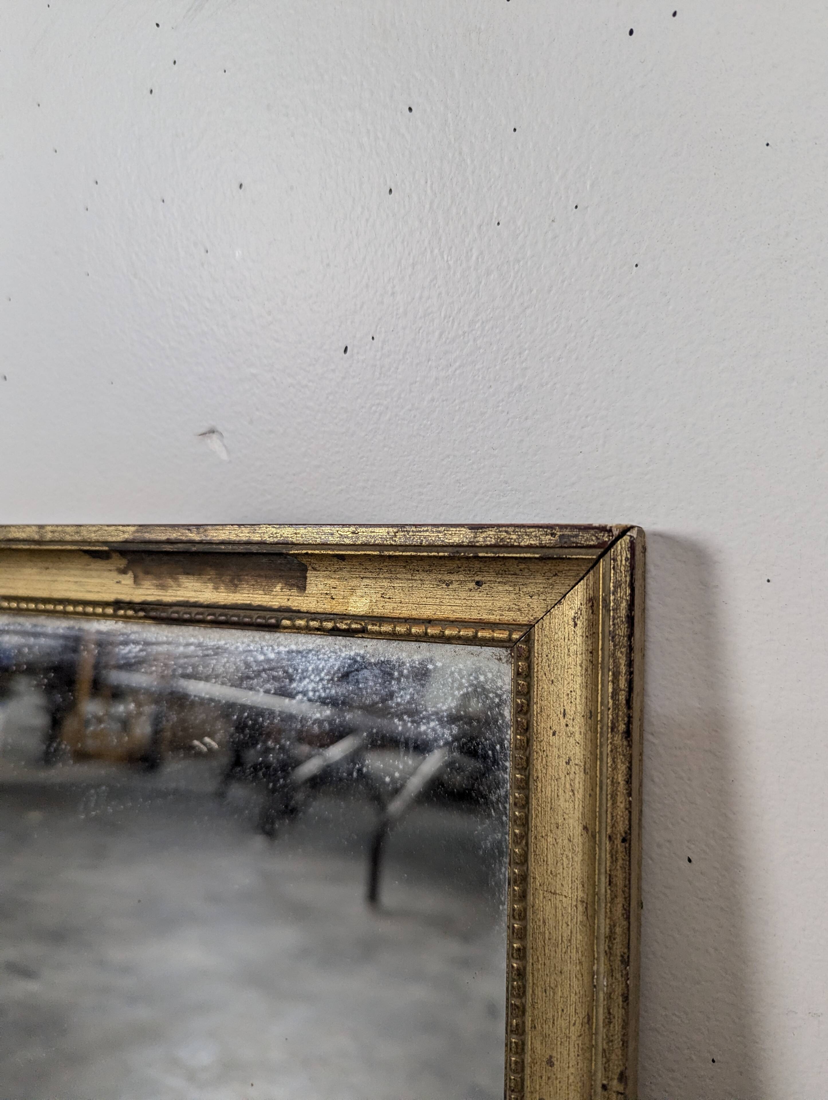 Rectangular mirror with a gold wooden frame.