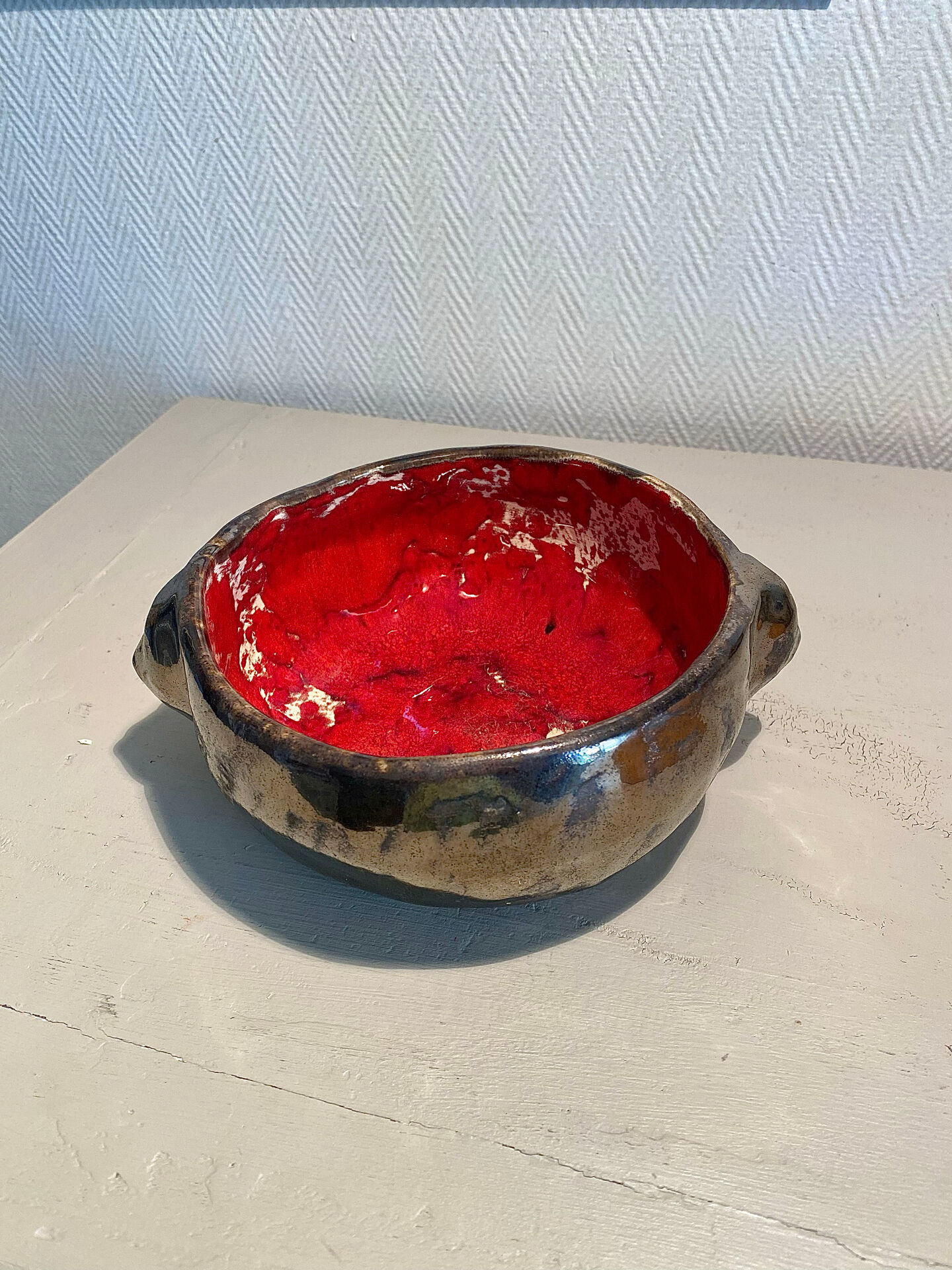 Deep red glazed and metallic ceramic catchall.