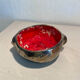Deep red glazed and metallic ceramic catchall.