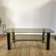 coffee table in smoked glass and black and gold metal from the 70s