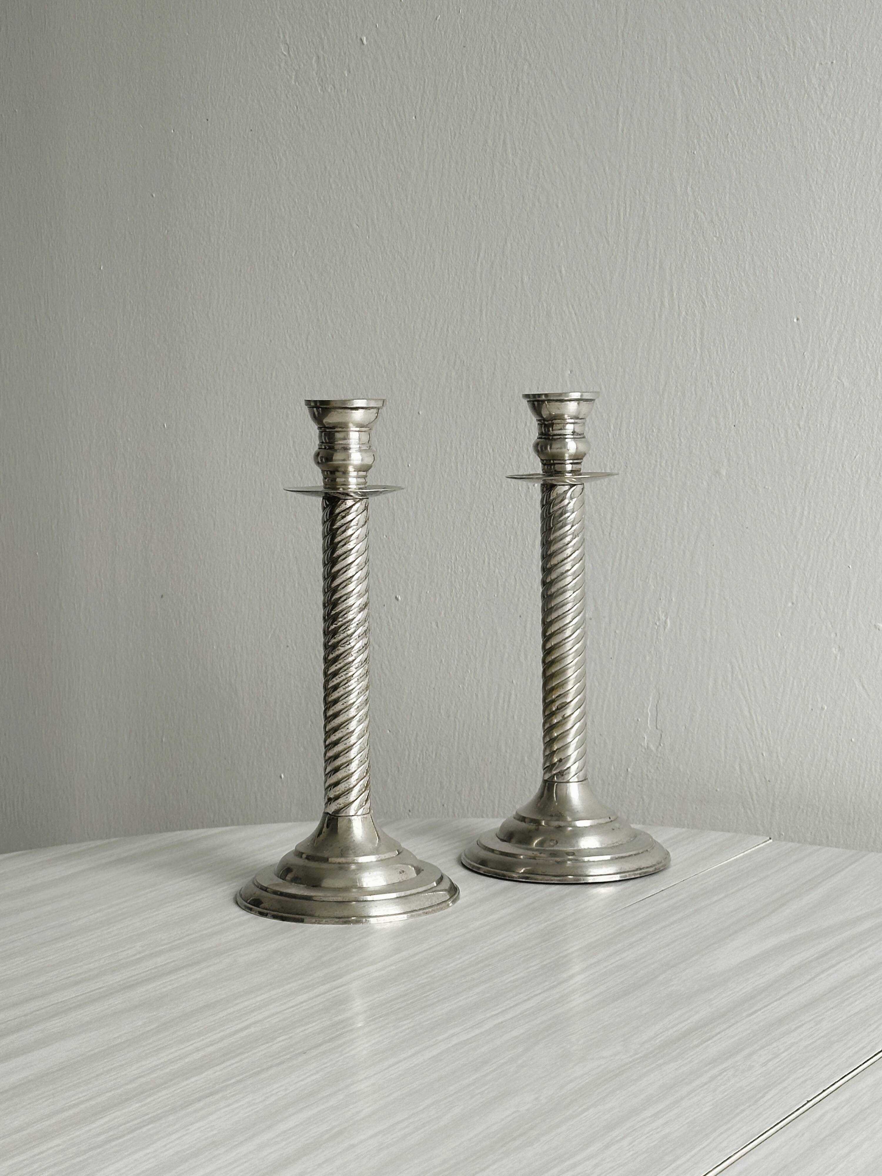 Patinated silver-plated metal candlesticks