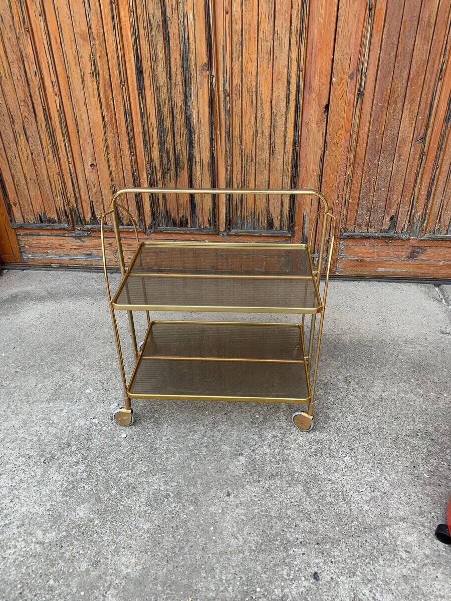 Chariot pliant vintage doré en laiton et plastique fumé à deux plateaux et roulettes