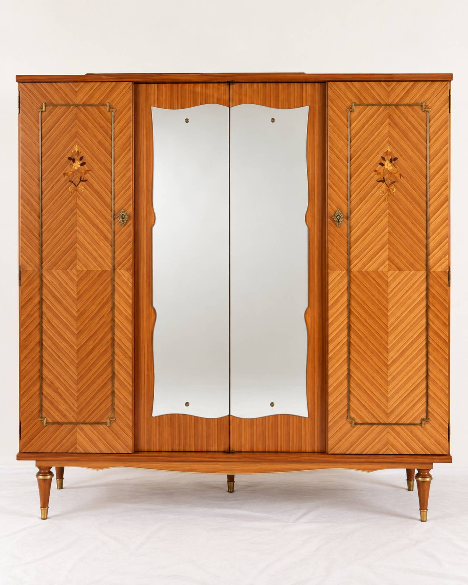 Vintage 1970s wardrobe with floral marquetry, mirrors, and gold details.