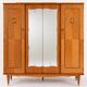 Vintage 1970s wardrobe with floral marquetry, mirrors, and gold details.