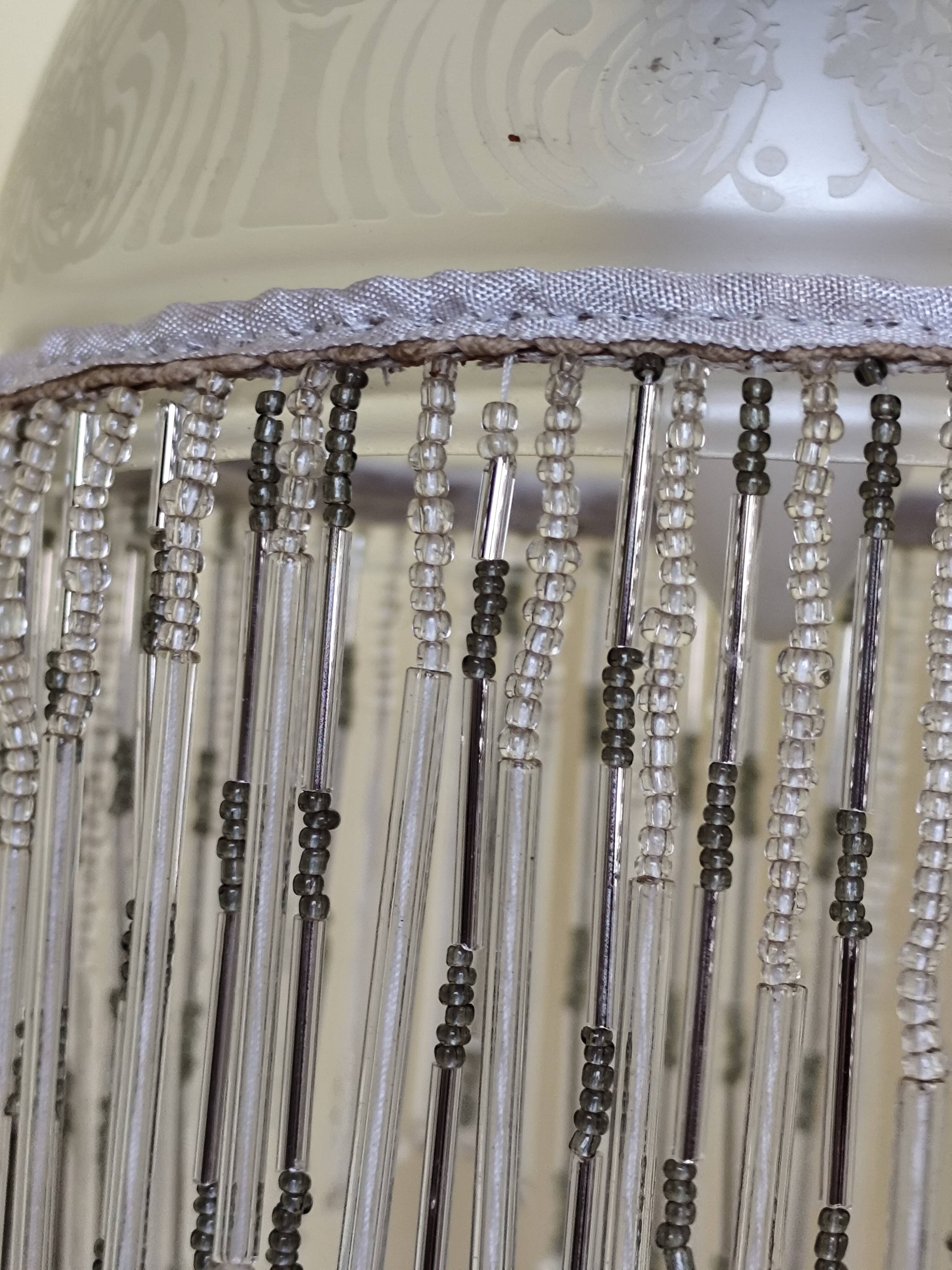 Retro brass lamp with a glass shade and bead fringes.