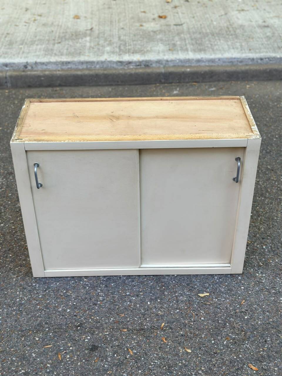 Vintage wall-mounted kitchen cabinet with sliding doors in 1960s retro style.