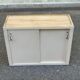 Vintage wall-mounted kitchen cabinet with sliding doors in 1960s retro style.