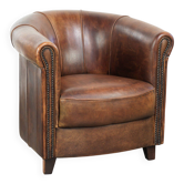 Fauteuil club en peau de mouton avec une belle patine, fini avec des clous décoratifs.