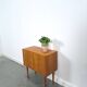 Commode danoise avec de hauts pieds et des poignées dorées.