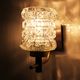 Pair of wall sconces in textured glass, wood, and gold metal, 1970.